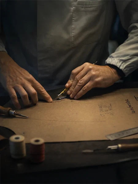 Craftsman cutting leather pattern for a premium men’s leather jacket